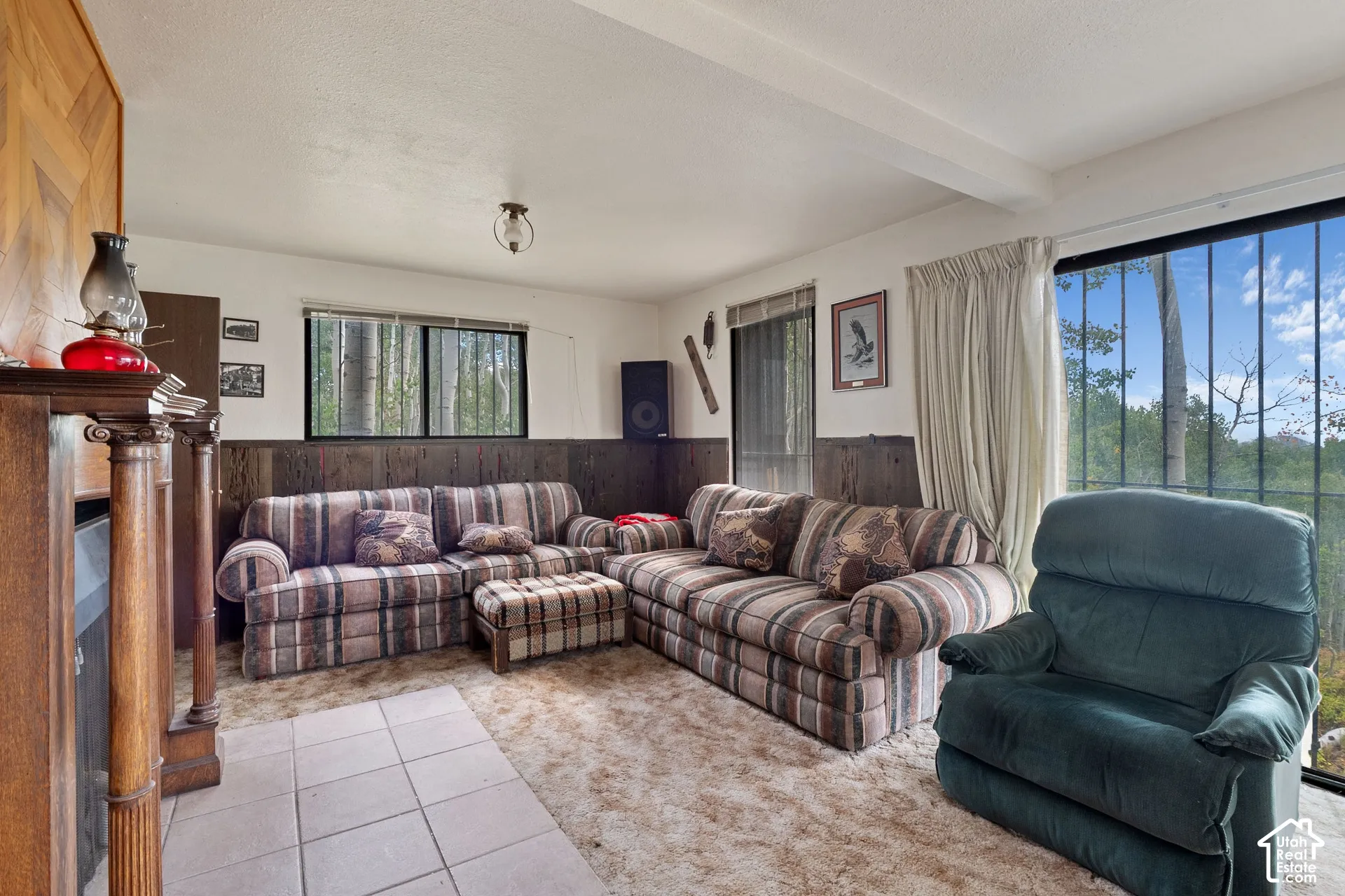 Room featuring a wood-panel accent wall and a classic fireplace mantel