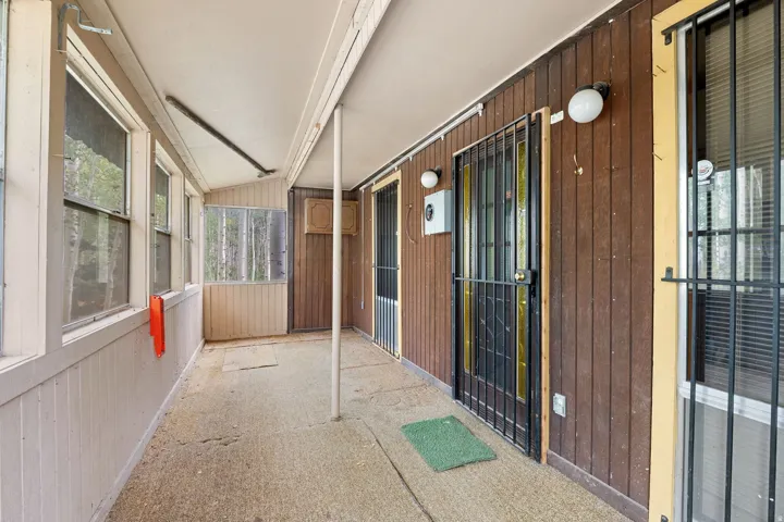 Screened porch with concrete flooring and wood-paneled walls