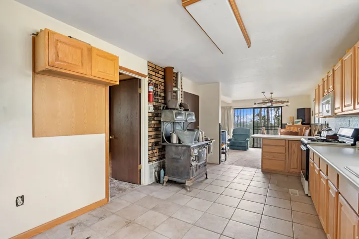 Kitchen featuring light wood cabinetry, a built-in range, and tile flooring