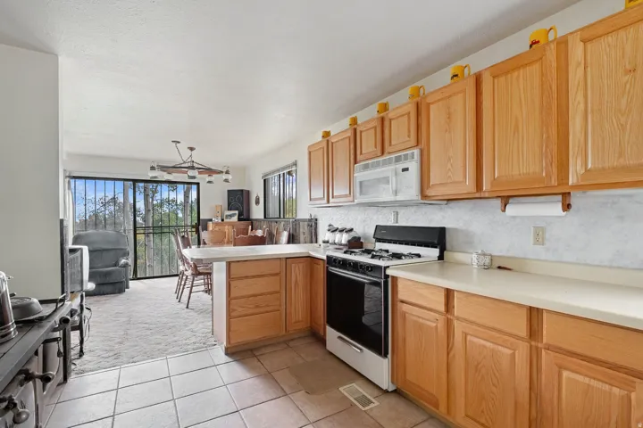 Kitchen featuring wood-finish cabinetry, white countertops, and tile flooring