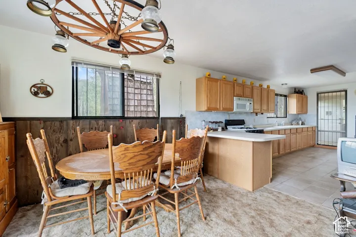 Open-concept kitchen and dining area featuring natural wood cabinetry and a central island