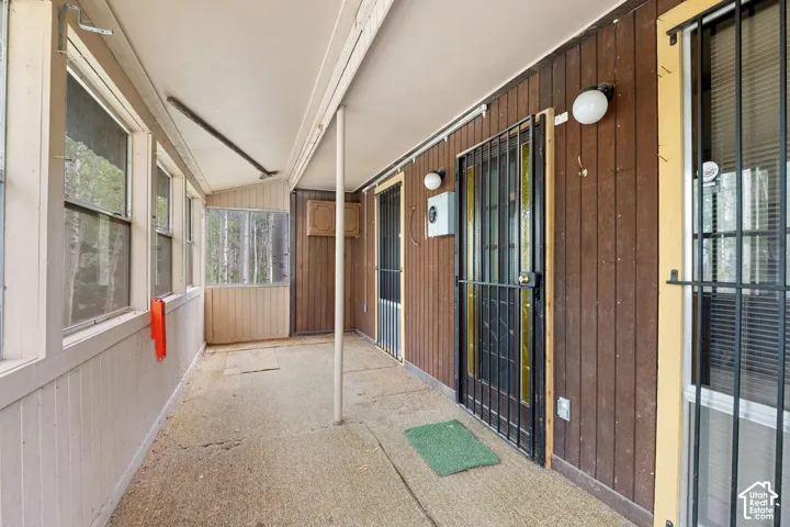 Screened porch with concrete flooring and wood-paneled walls