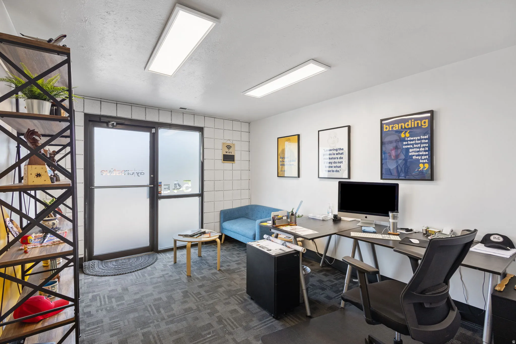 Commercial space featuring a frosted glass entry door, white tile wall accents, and patterned carpet flooring