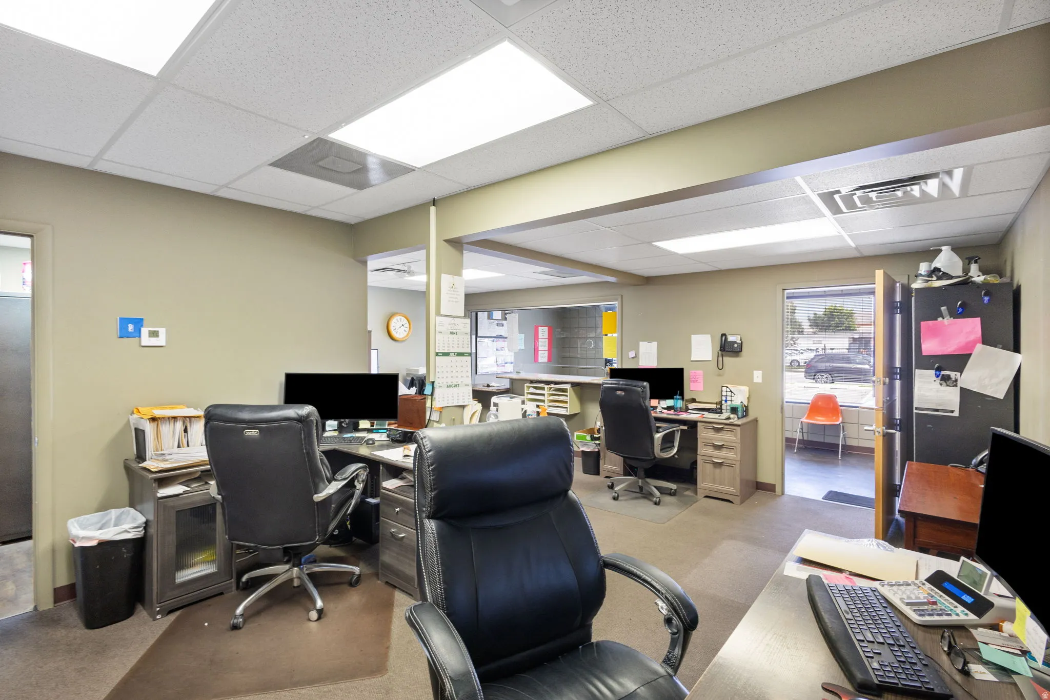 Open office space featuring drop ceiling with integrated lighting