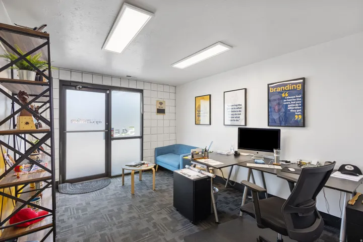 Commercial space featuring a frosted glass entry door, white tile wall accents, and patterned carpet flooring