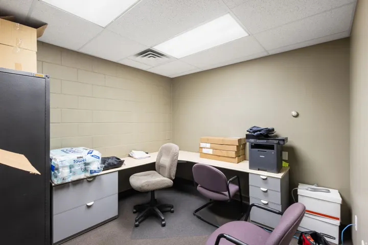 Functional office space featuring modular desk configuration with dual work stations, ergonomic seating, and ample built-in storage cabinetry