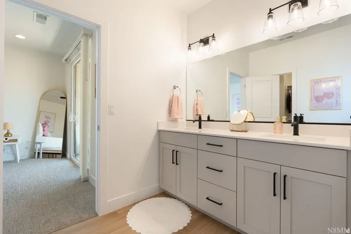 Spa-inspired primary bathroom featuring a double-sink vanity with gray cabinetry, brushed nickel hardware, and a quartz countertop