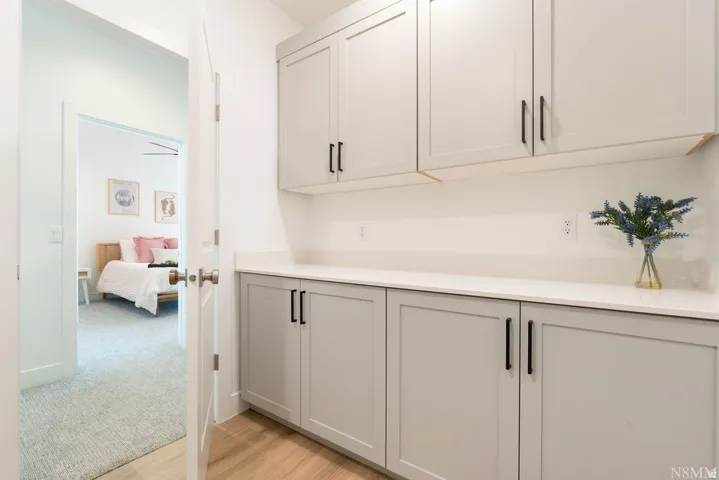 Sophisticated butler's pantry and prep kitchen featuring custom cabinetry with soft-close hardware, quartz countertops, and stainless steel fixtures