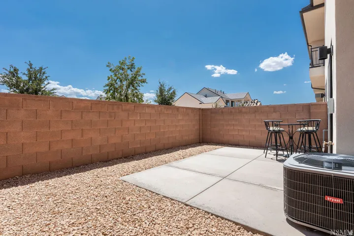 Spacious backyard retreat featuring a generous concrete patio, decorative gravel landscaping, and a sturdy brick privacy fence