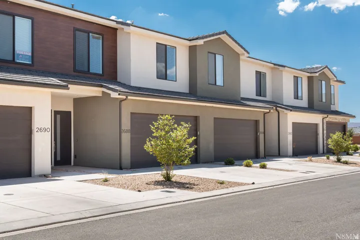 Modern townhome community featuring clean-lined architecture with mixed exterior finishes in cream and warm taupe tones