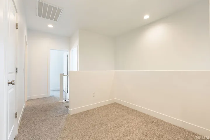 Spacious finished room featuring neutral wall finishes, recessed ceiling lighting, and plush carpet flooring