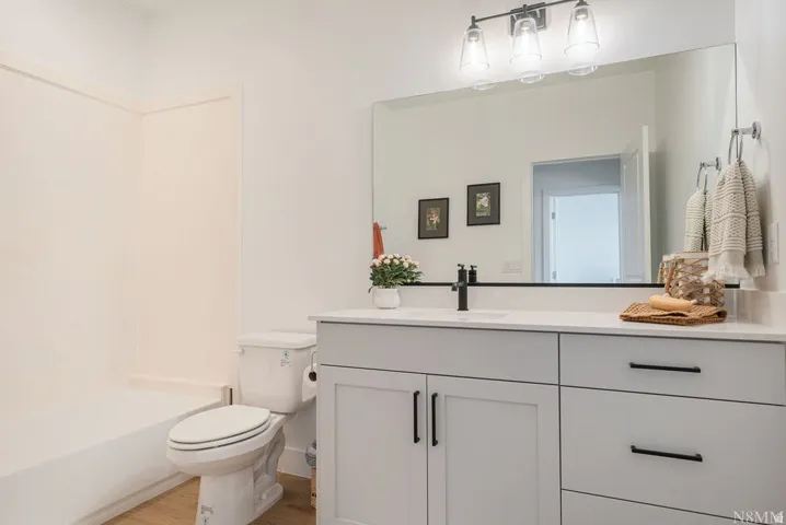 Spa-inspired bathroom featuring a floating vanity with dual drawers, white quartz countertop, and integrated sink