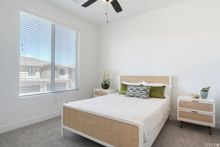 Neutral tone bedroom featuring white walls and grey carpet flooring