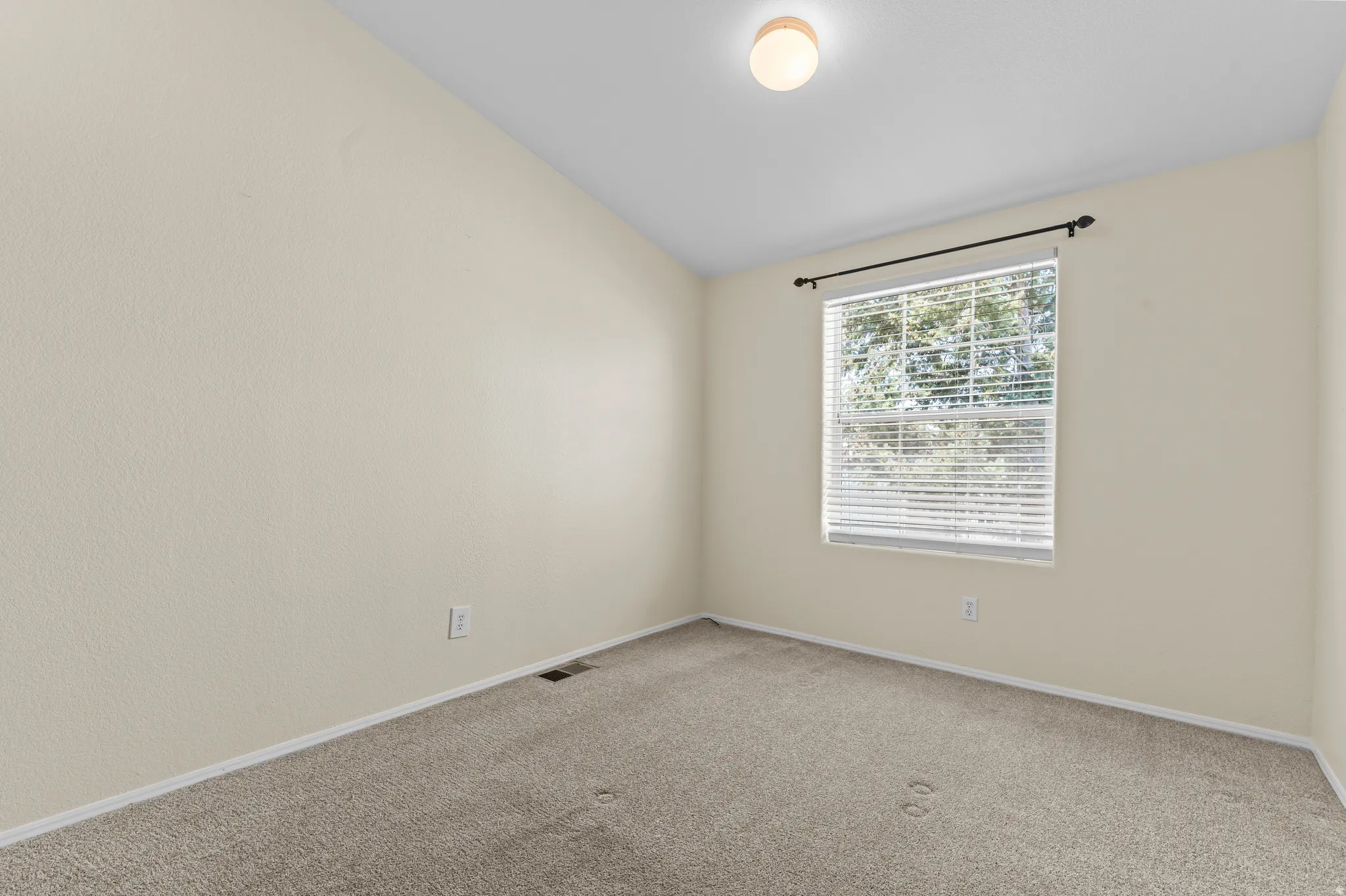 Bright bedroom featuring neutral carpet flooring.