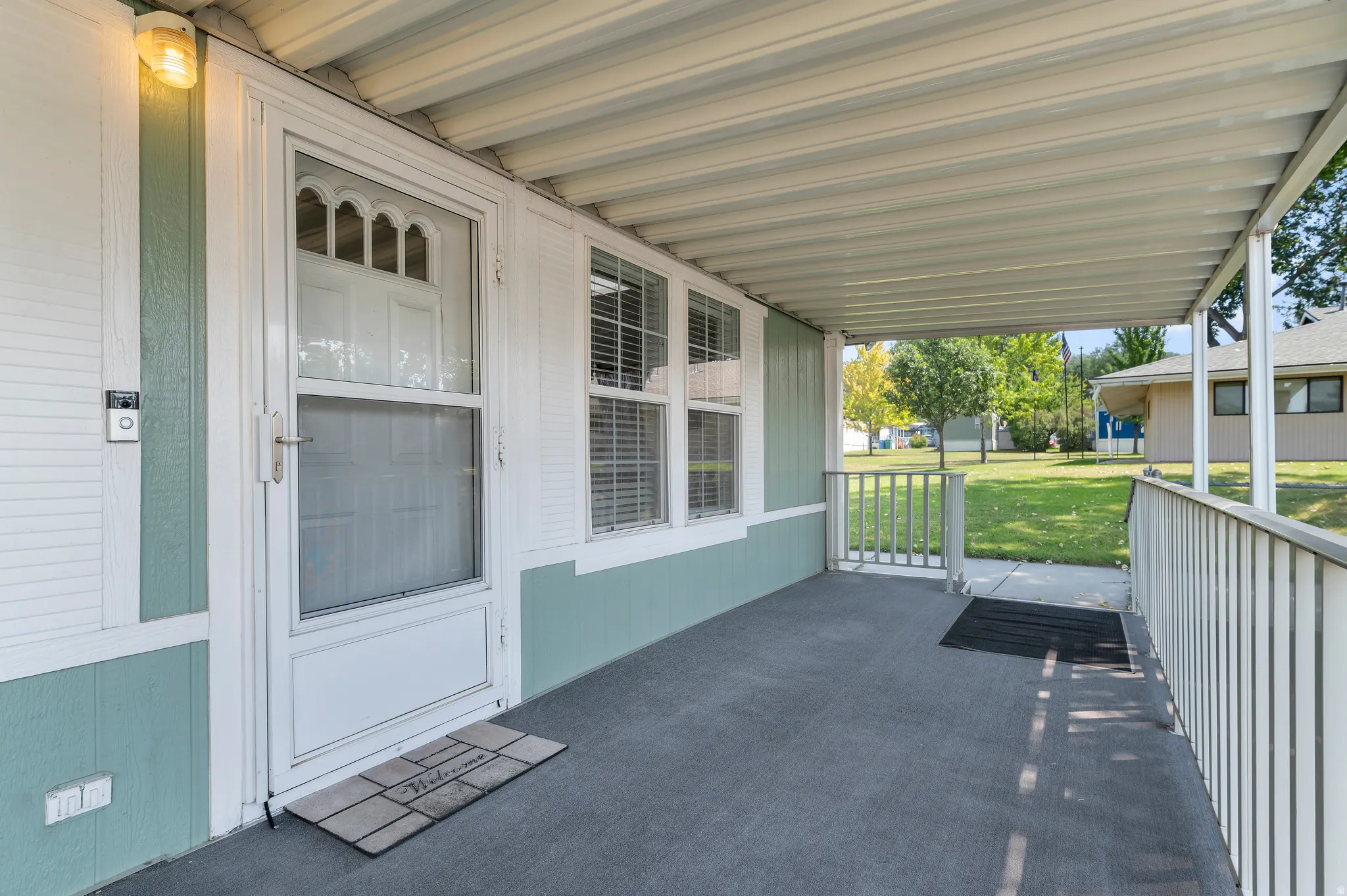 Covered porch featuring durable flooring and white railing