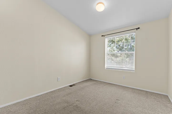 Bright bedroom featuring neutral carpet flooring.