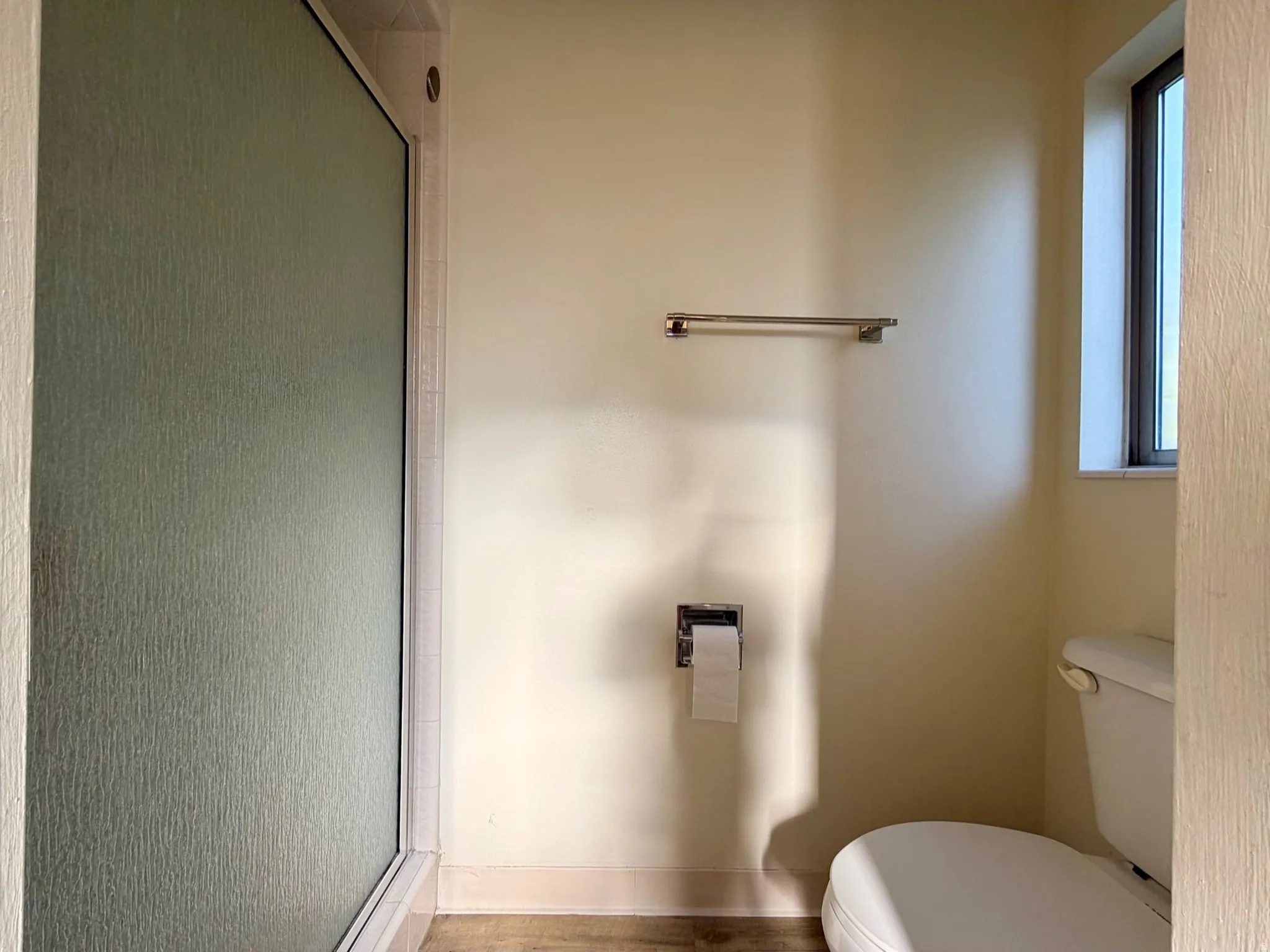 Bathroom featuring a skylight, white toilet, and textured flooring