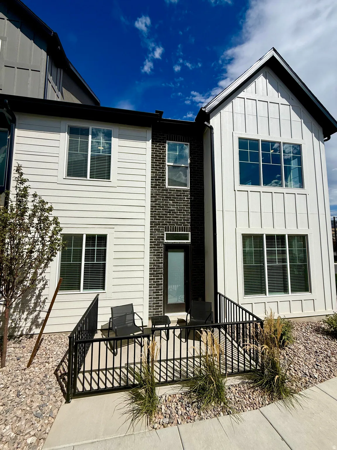 Multi-story exterior with board and batten siding, horizontal siding, and brick accents