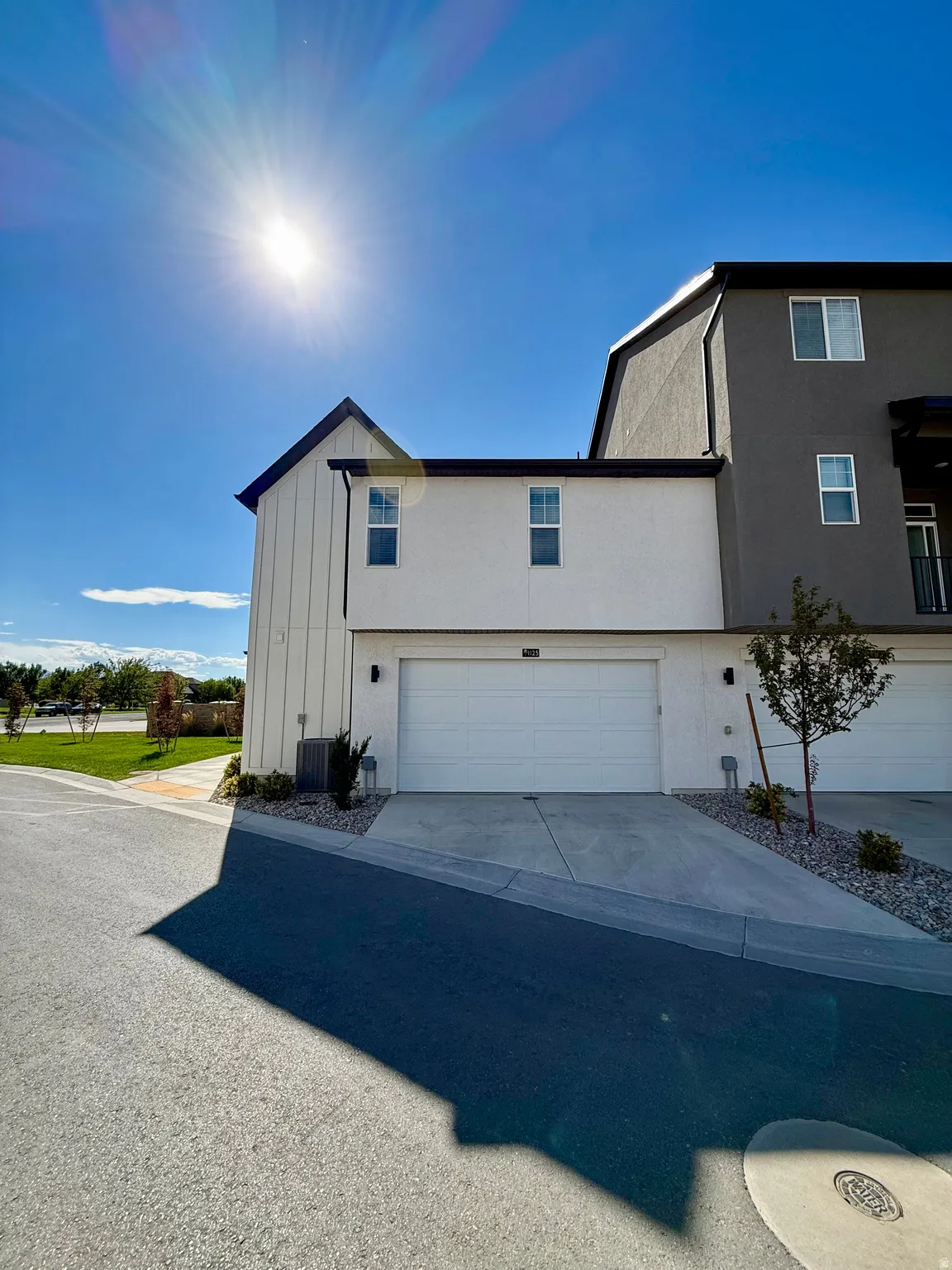 Contemporary exterior with white board and batten siding, dark gray stucco, and a white garage door