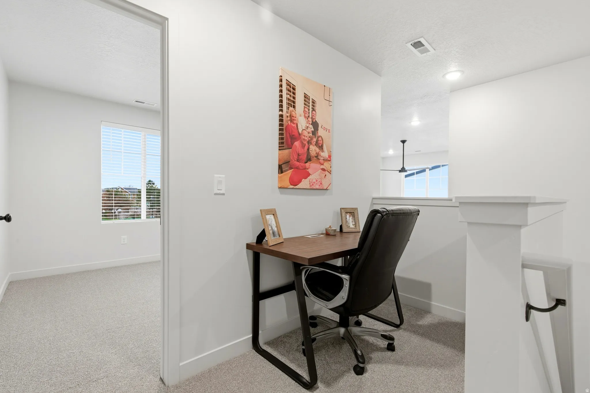 Dedicated workspace featuring light gray carpeting and bright white walls