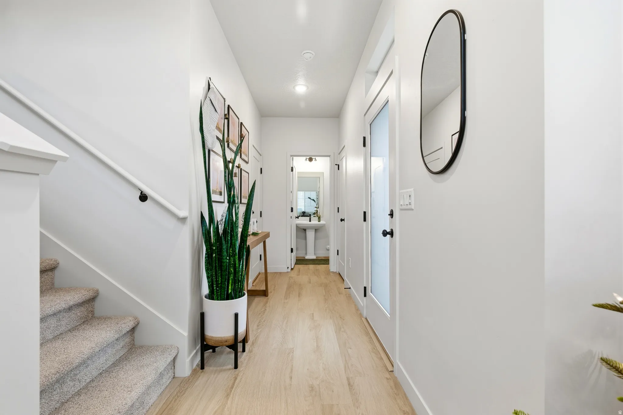 Hallway featuring wood-finish flooring, white walls, and recessed lighting
