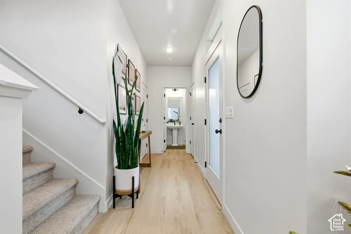 Hallway featuring wood-finish flooring, white walls, and recessed lighting