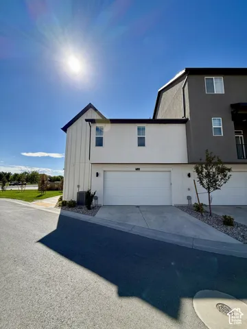 Contemporary exterior with white board and batten siding, dark gray stucco, and a white garage door