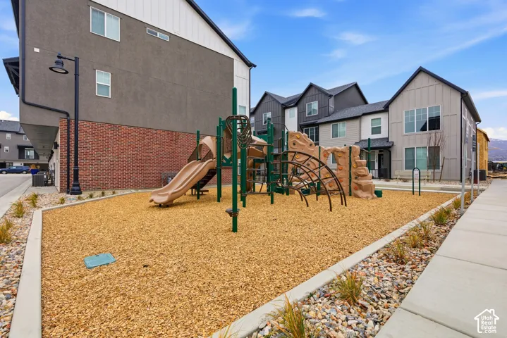 Community playground featuring a climbing structure, slide, and wood chip surfacing