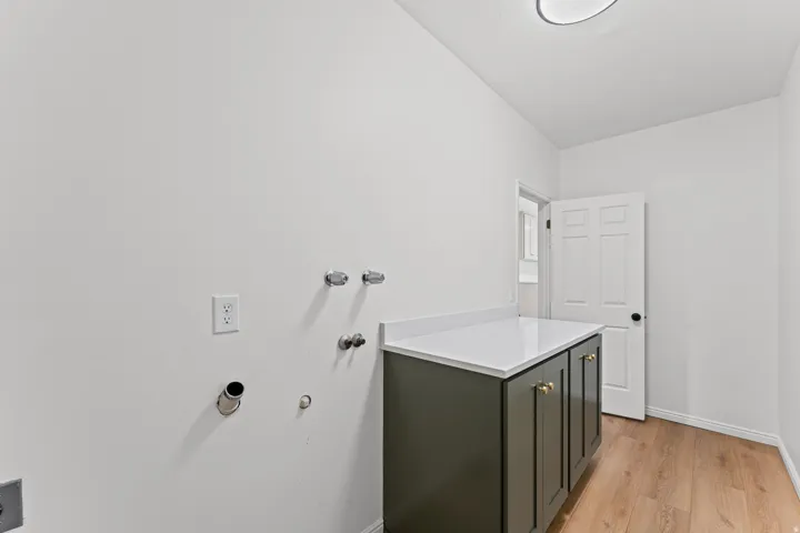 Modern bathroom vanity featuring a dark cabinetry base with white quartz countertop, chrome wall-mounted fixtures, and polished chrome hardware