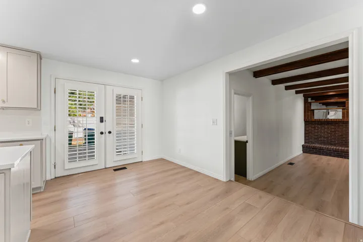 Bright room featuring a light wood-finish flooring, recessed lighting, and white walls
