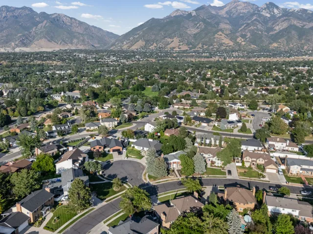 Aerial view showcasing this residential community nestled in a valley setting with mature landscaping throughout the neighborhood