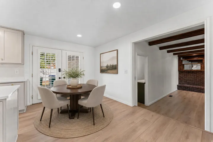 Bright dining space featuring wood-finish flooring, recessed lighting, and double French doors