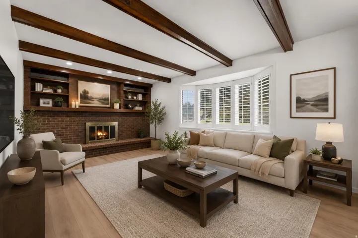 Sophisticated living room showcasing exposed wood beam ceiling details, a brick fireplace with built-in shelving and cabinetry, and hardwood flooring throughout