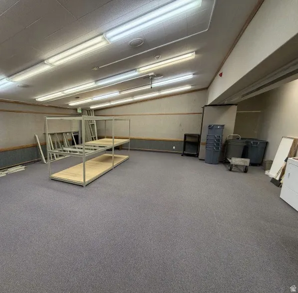 Spacious commercial or industrial space featuring polished concrete flooring, recessed and linear fluorescent ceiling lighting, and neutral wall finishes