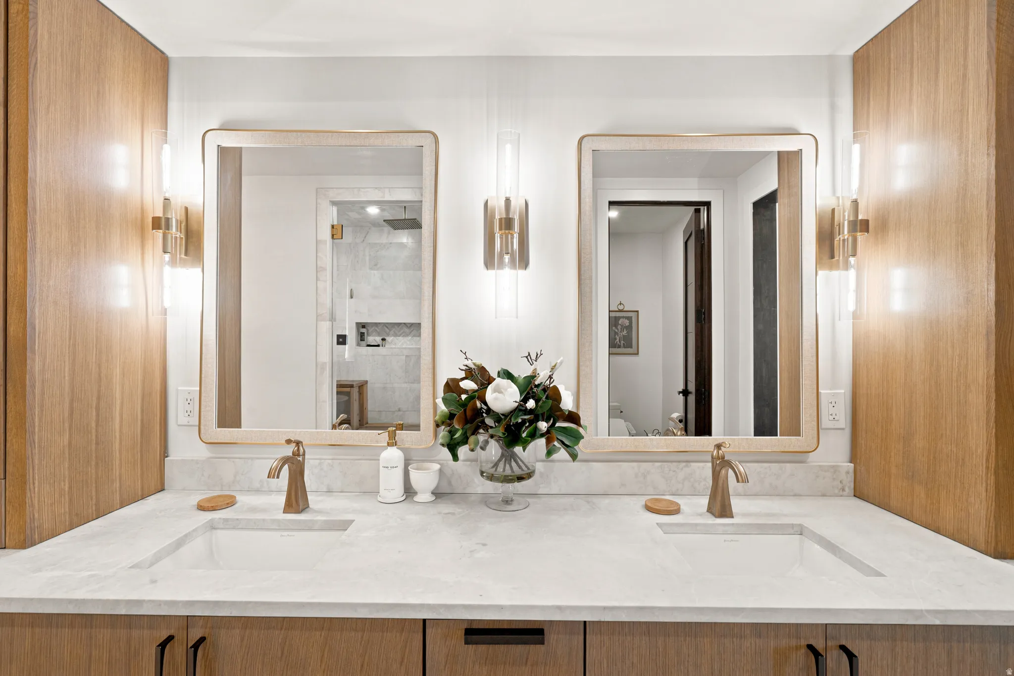 Double vanity featuring integrated sinks and brushed brass fixtures