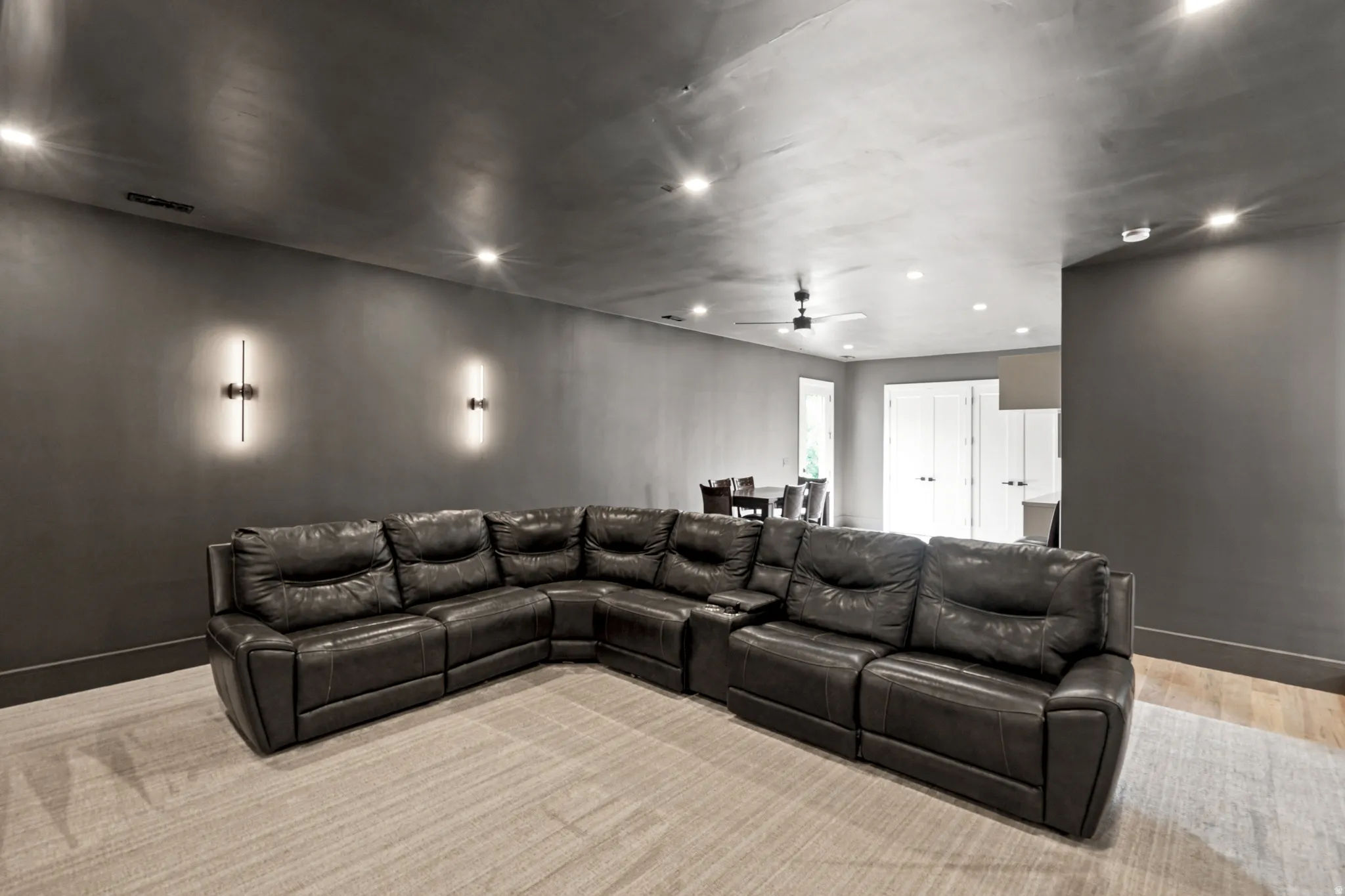 Spacious room featuring recessed lighting and two contemporary wall sconces