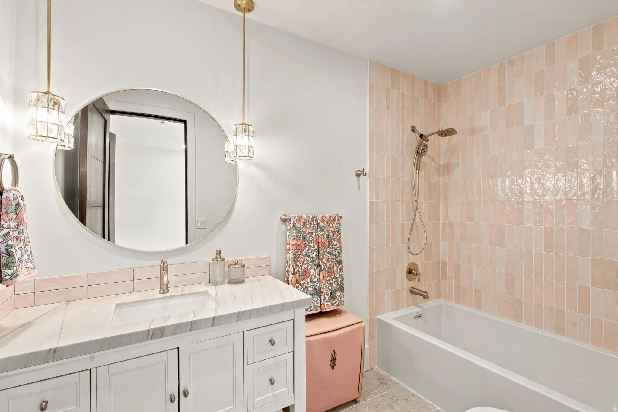 Bathroom featuring a white vanity with a marble-finish countertop, undermount sink, and brass-tone faucet