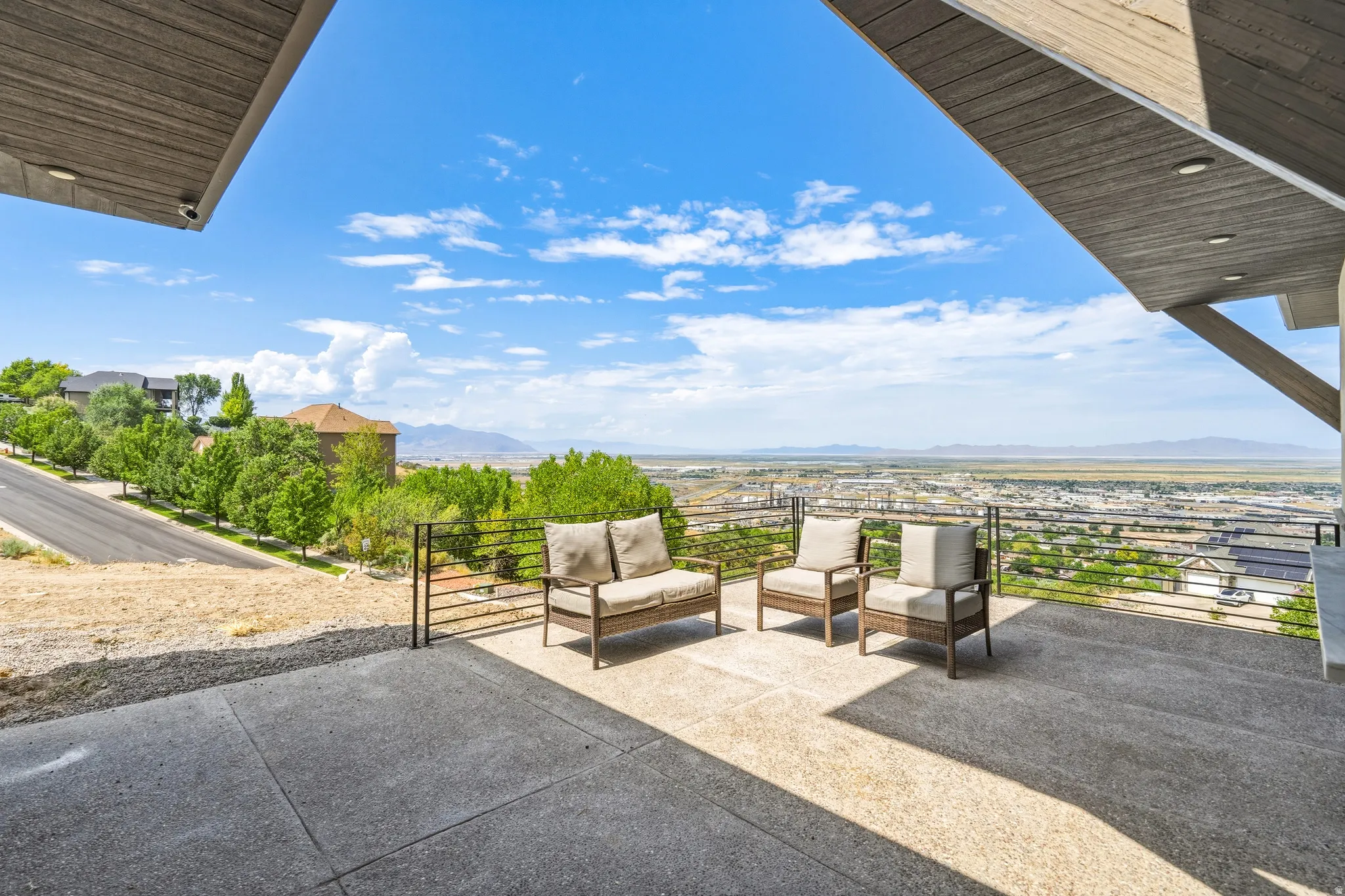 Expansive concrete patio offering broad vistas of the surrounding landscape and distant mountains
