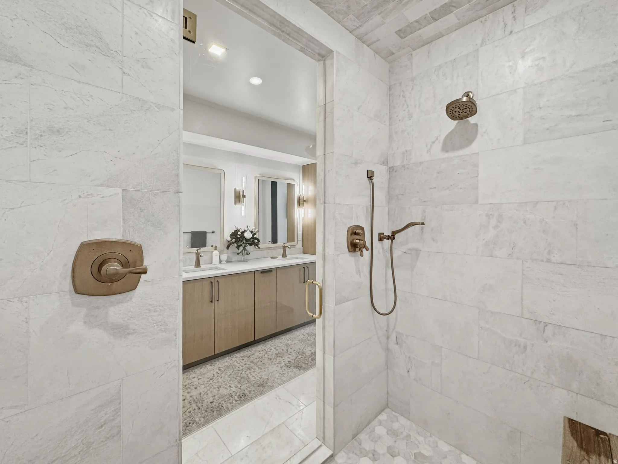Spacious shower enclosure with large format wall tiles and hexagonal floor tiles