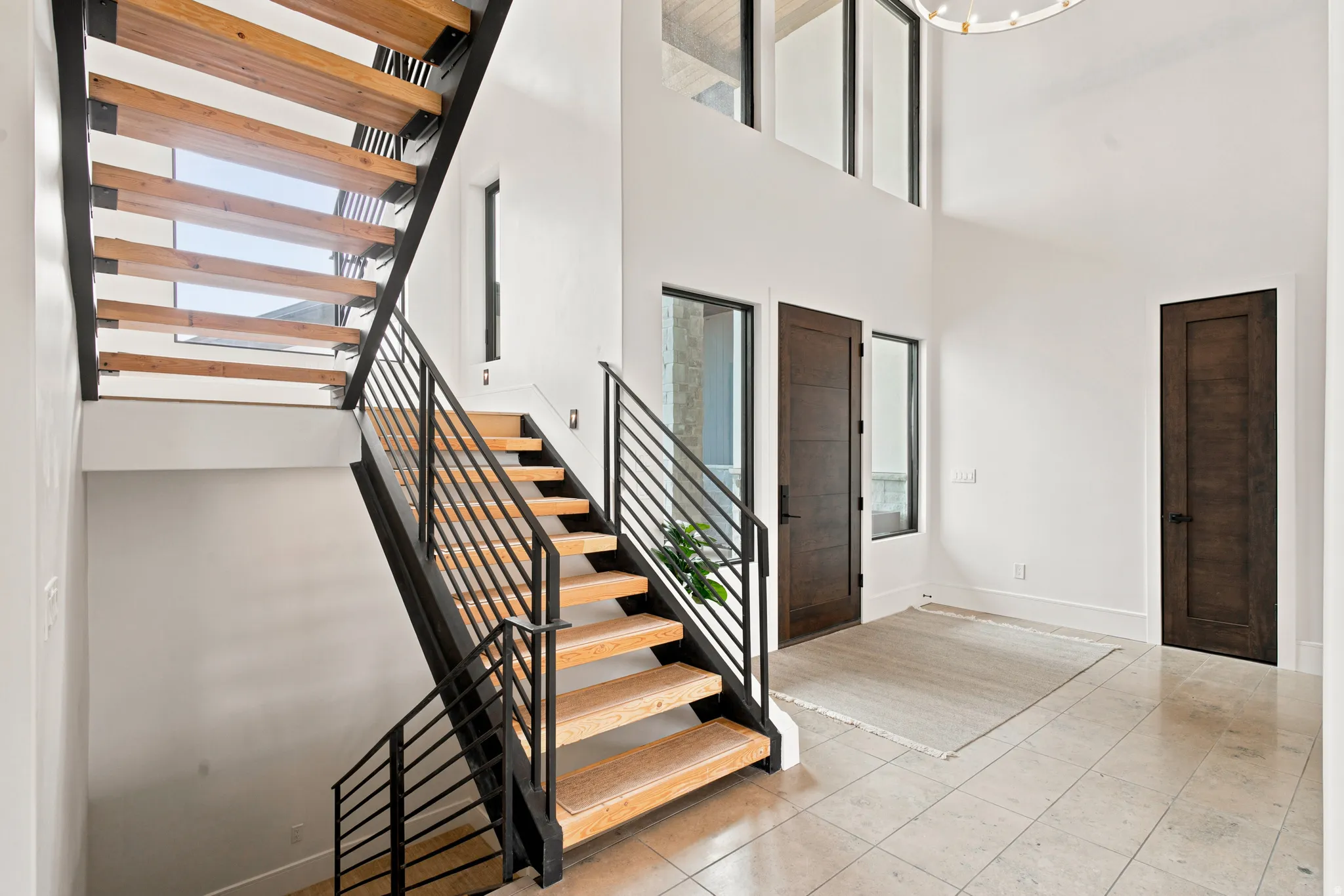 Entryway featuring a floating staircase with wood treads and black metal railings