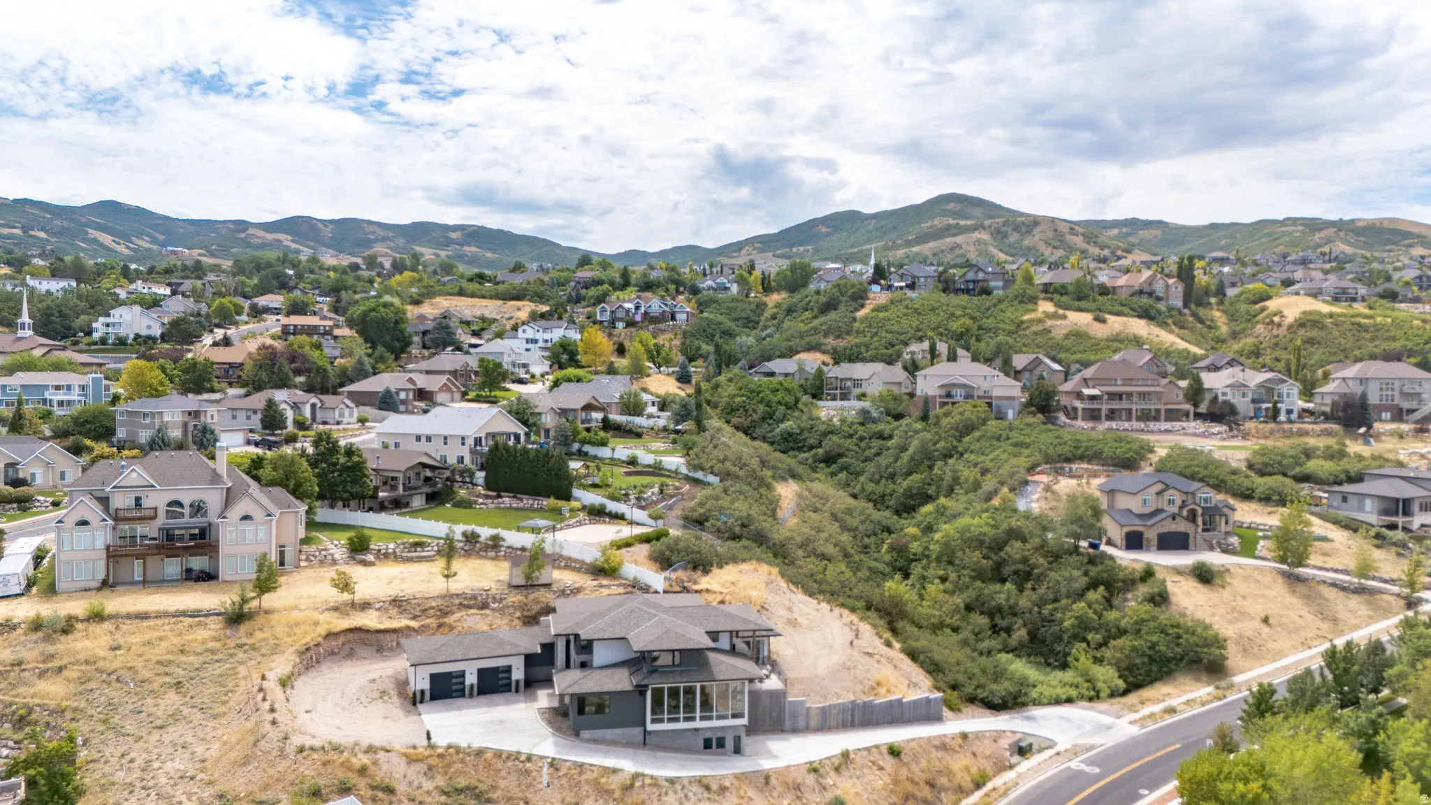 Modern multi-level residence with an attached three-car garage and a paved driveway