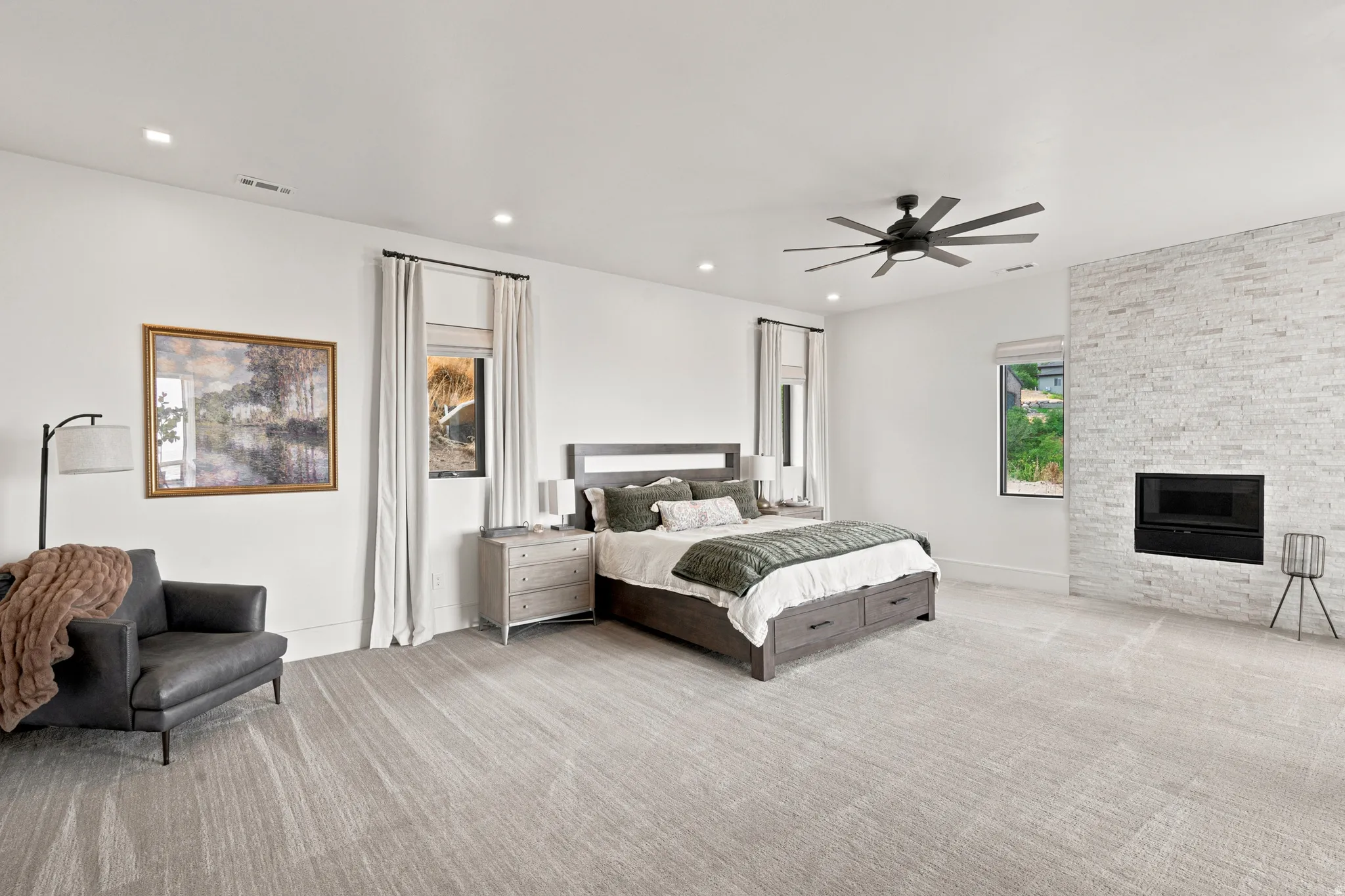 Spacious room featuring light-toned carpeting, a contemporary ceiling fan, and recessed lighting