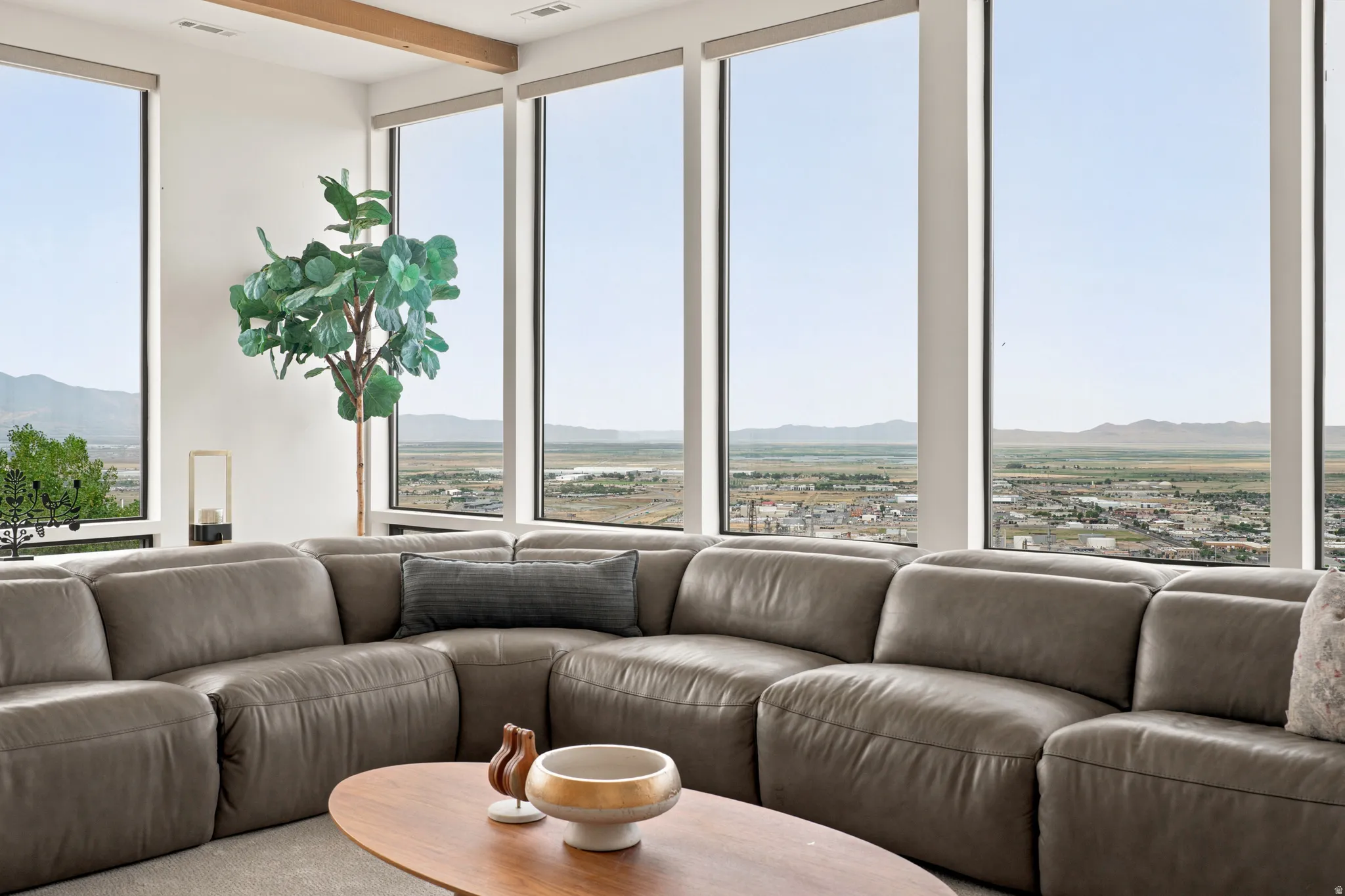 Expansive window wall with mountain and cityscape scenery