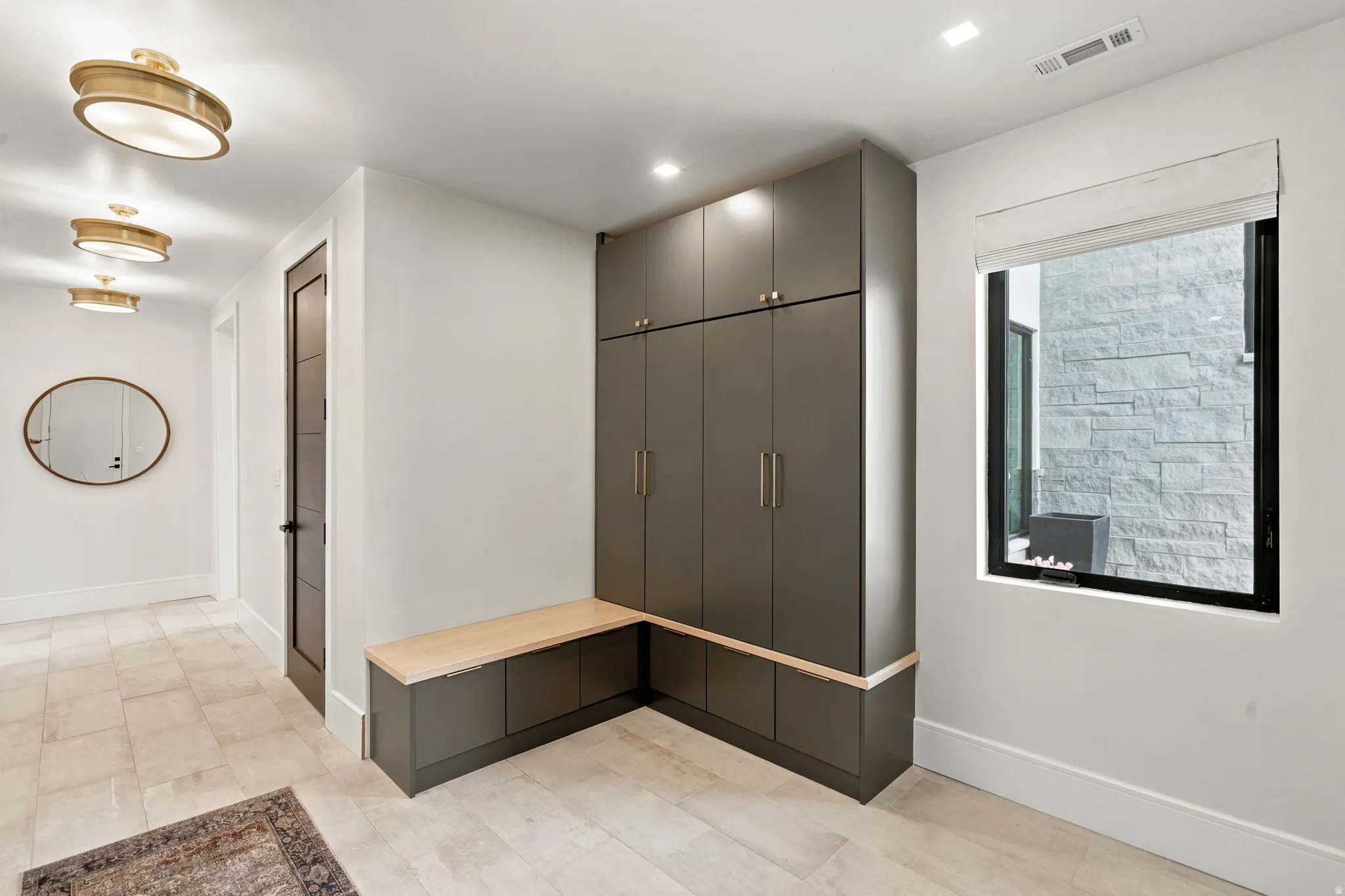 Entry area featuring tile flooring and a built-in storage unit with a wood-finish bench