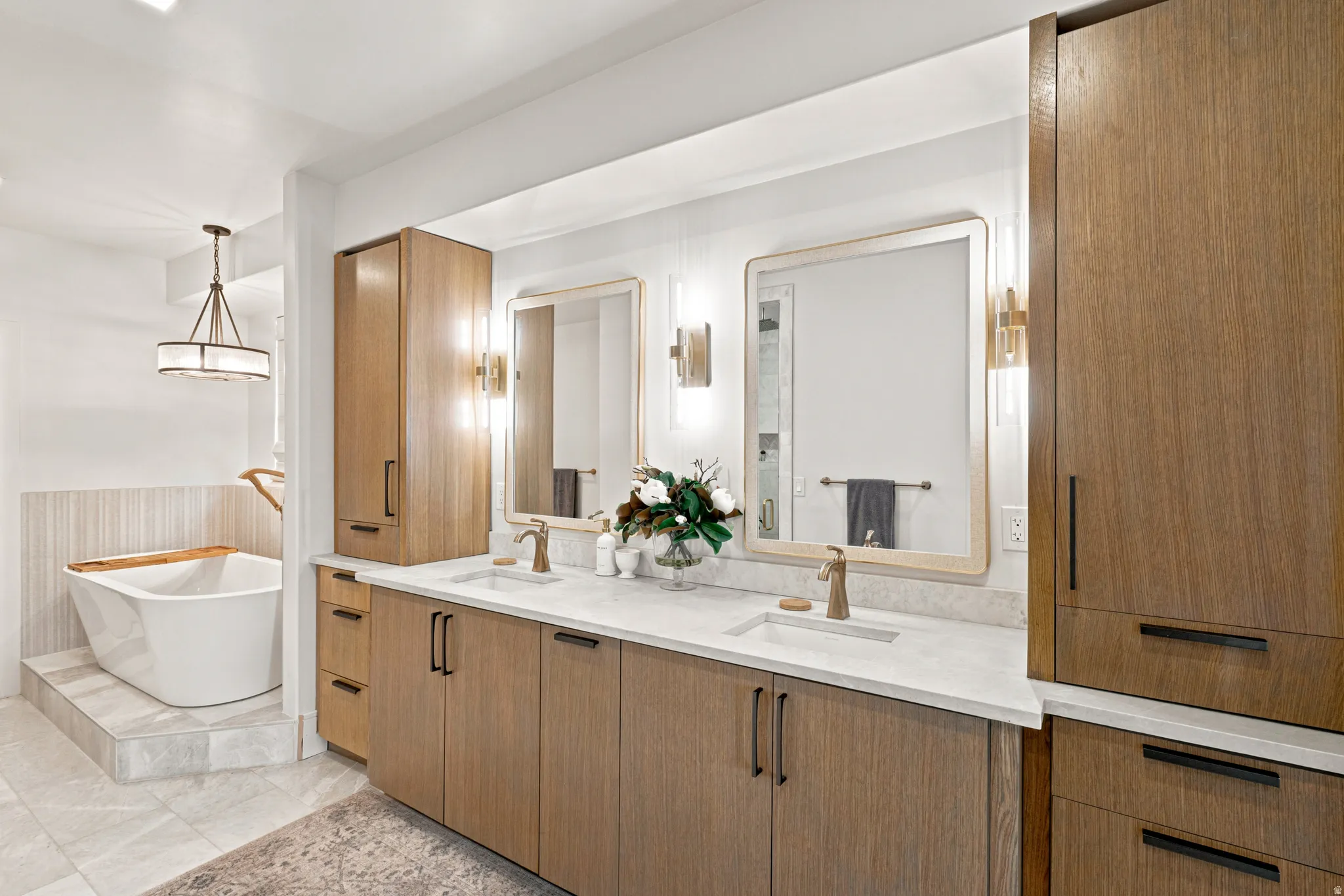 Dual vanity featuring wood-finish cabinetry, white stone countertops, and integrated rectangular sinks
