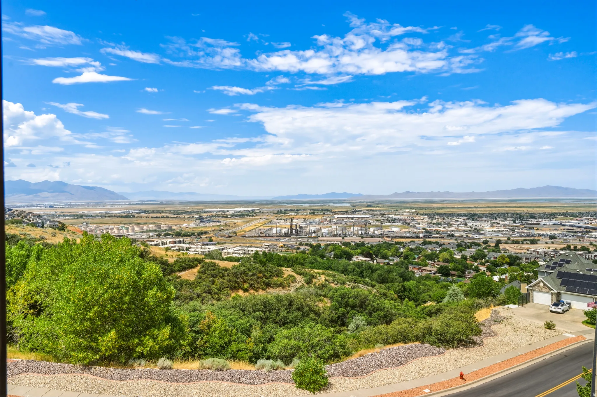 Expansive landscape featuring distant mountains, a sprawling cityscape, and a verdant foreground