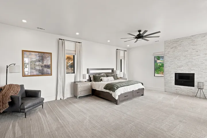 Spacious room featuring light-toned carpeting, a contemporary ceiling fan, and recessed lighting