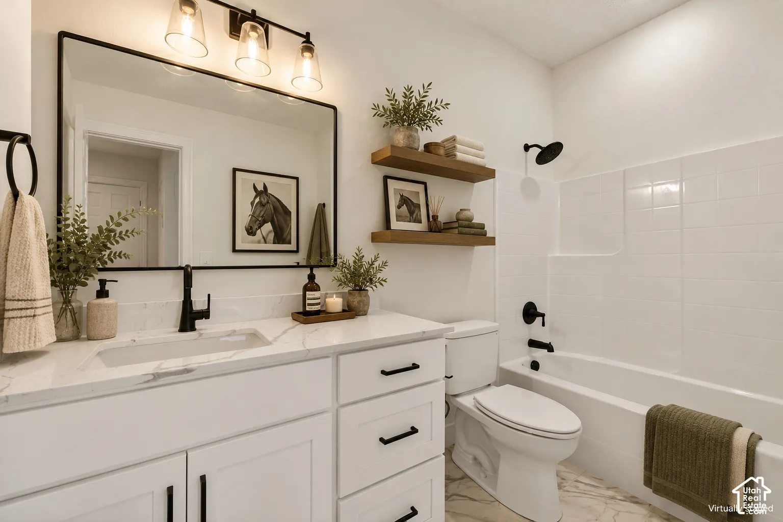 Bathroom featuring a white vanity with a stone-finish countertop, matte black fixtures, a framed rectangular mirror, wall-mounted wood-finish shelving, and a tiled tub-shower combination