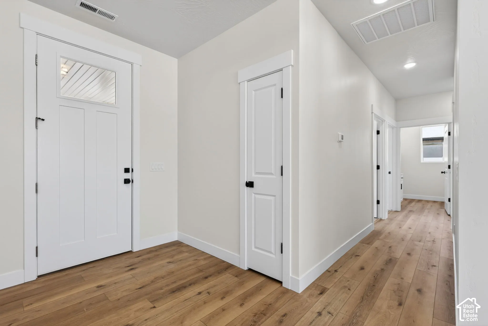 Entryway featuring a white paneled door with glass insert, wood-finish flooring, recessed lighting, and white trim