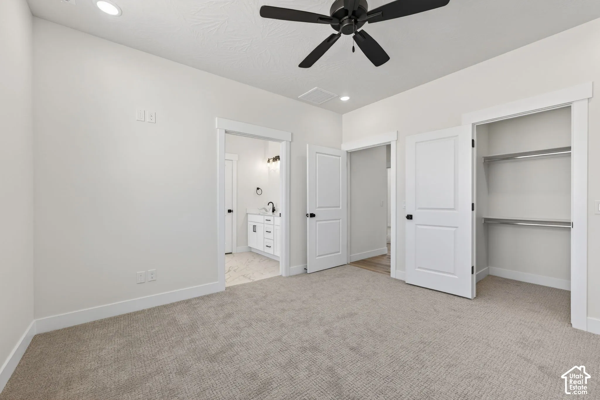 Carpeted room featuring a ceiling fan with integrated lighting, recessed lighting, white trim, and white two-panel doors